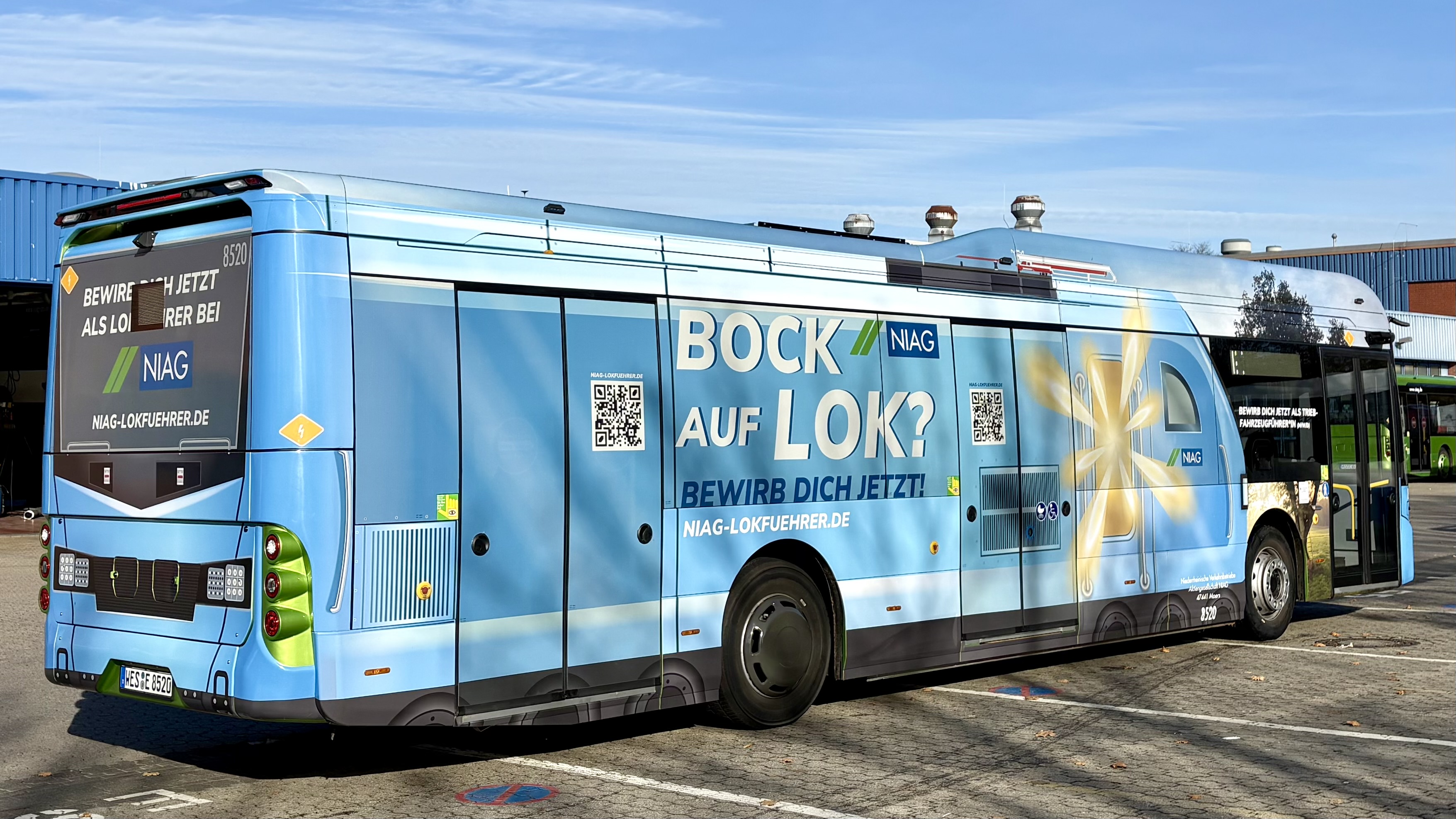 Ein NIAG-Bus mit Sonderbeklebung steht draußen im Depot.