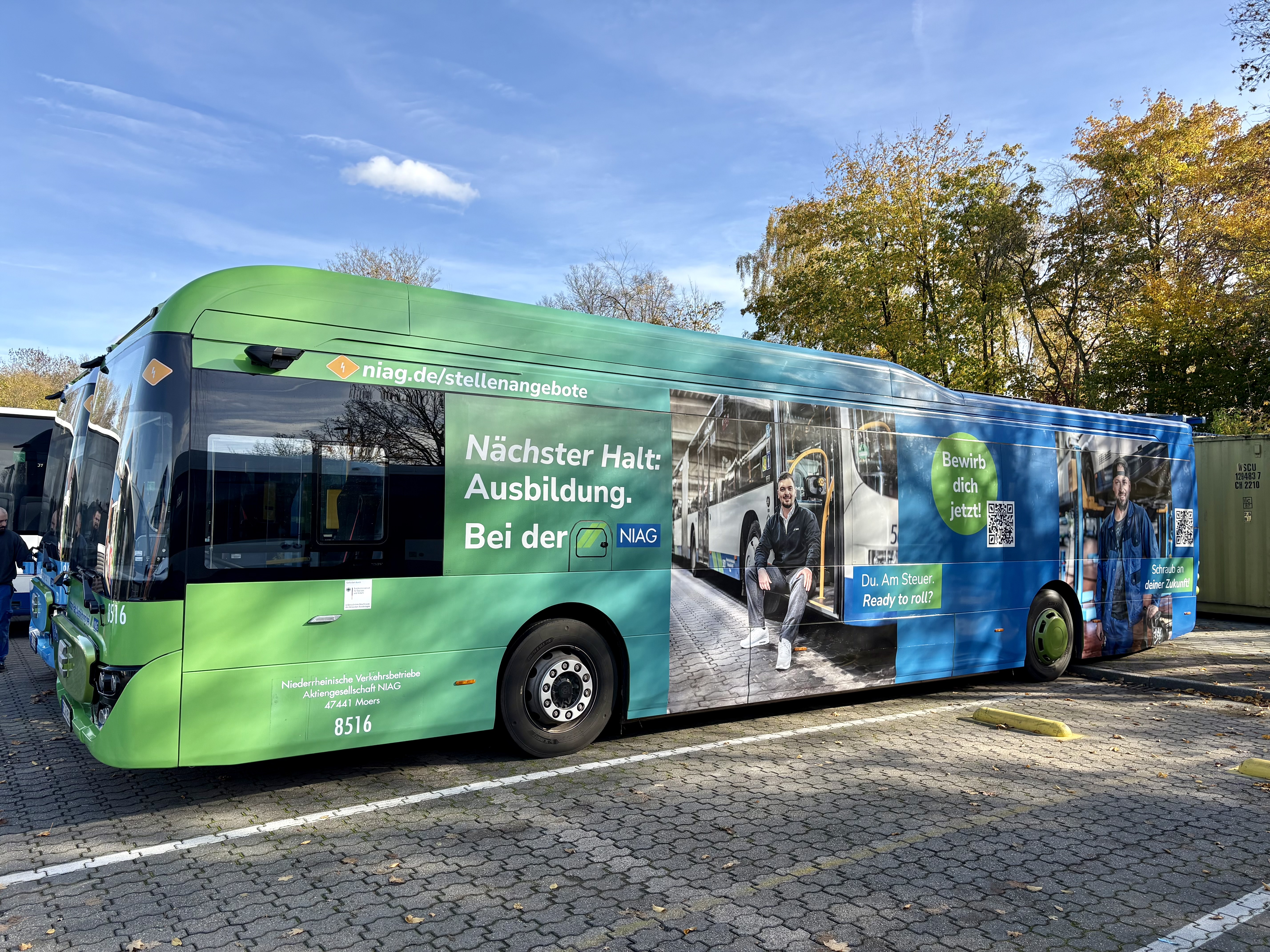 Ein NIAG-Bus mit Sonderbeklebung steht draußen im Depot.