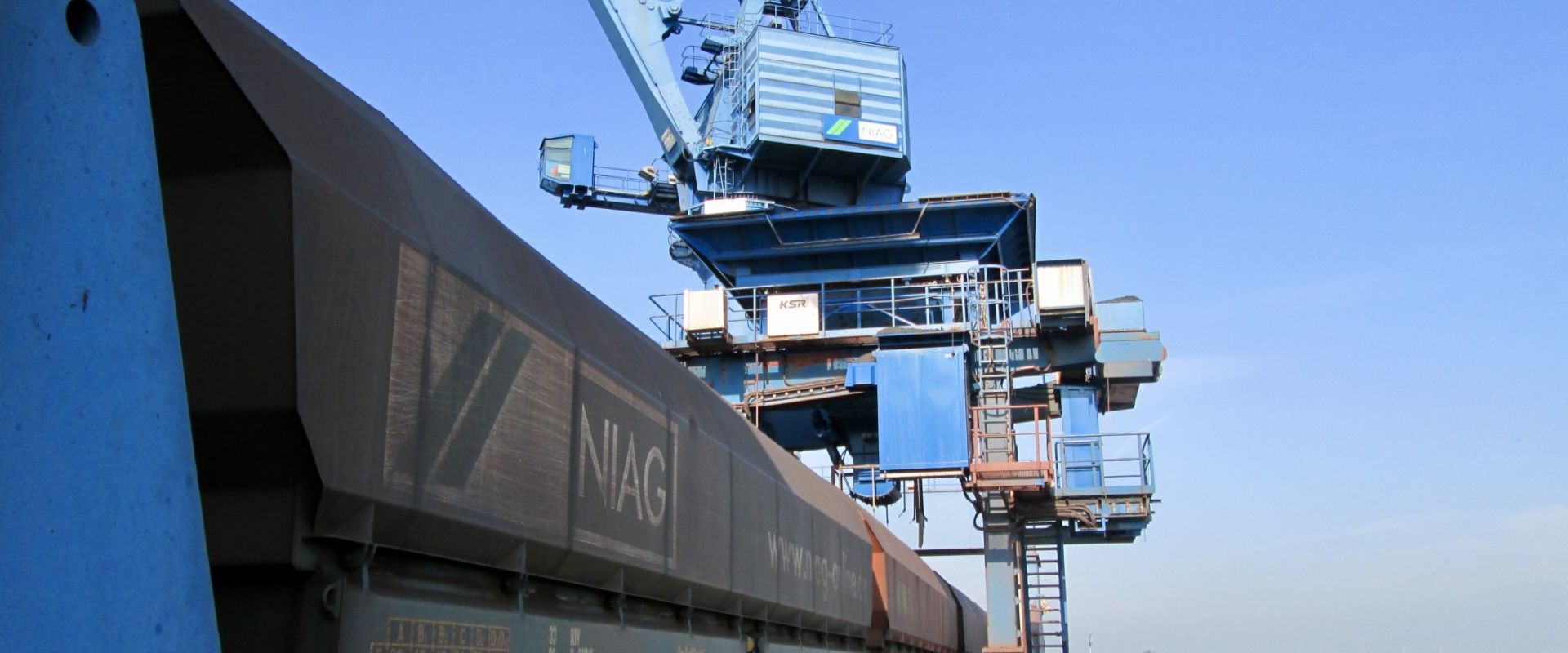 Ein Güterzug im Rheinhafen Orsoy mit Hafenkran im Hintergrund